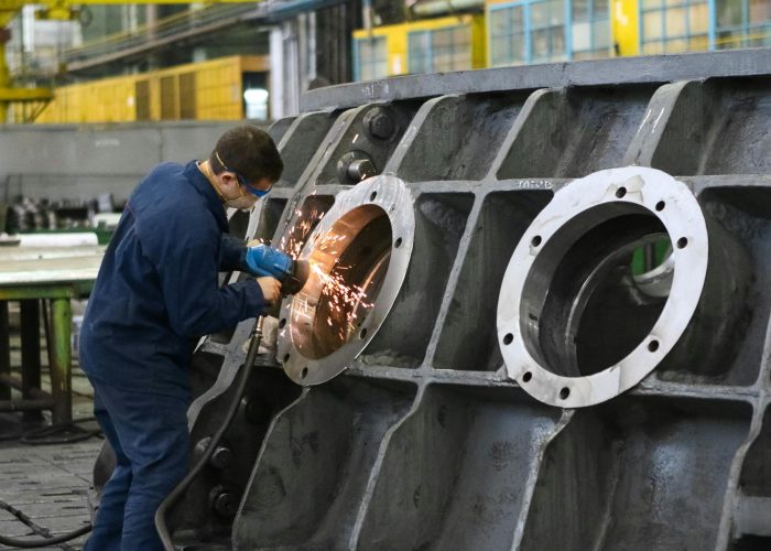 A man filing a metal pipe